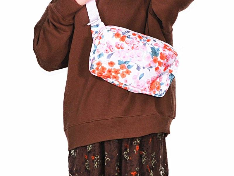 A girl dressed in brown carries a floral fanny pack.