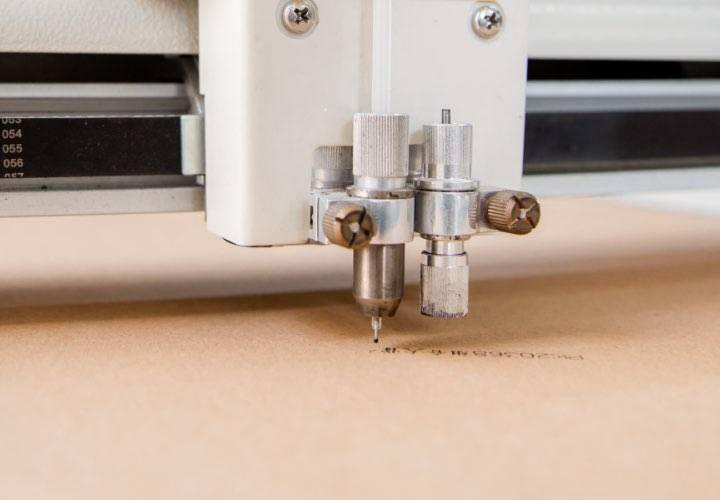 A digital printer prints on kraft paper bag products.