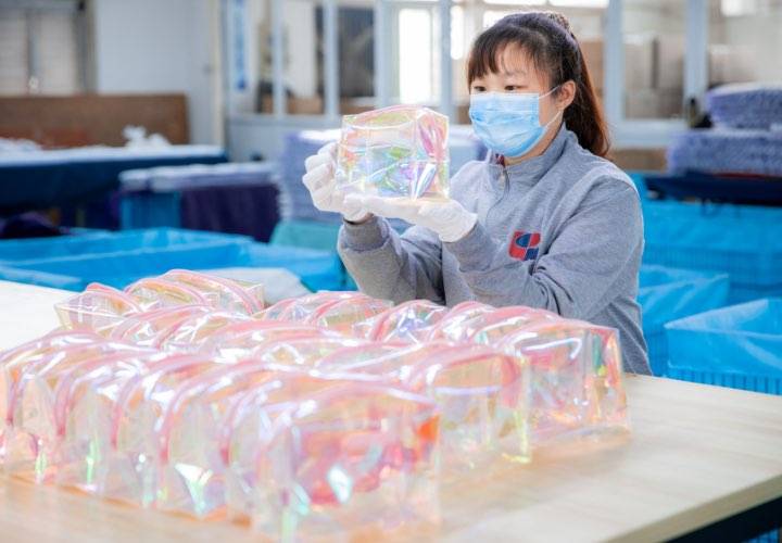 A quality inspector is carefully inspecting our finished toiletry bags.